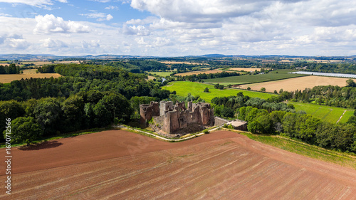 Historic Norman castle ruin surrounded by farmland and forest in Herefordshire, England