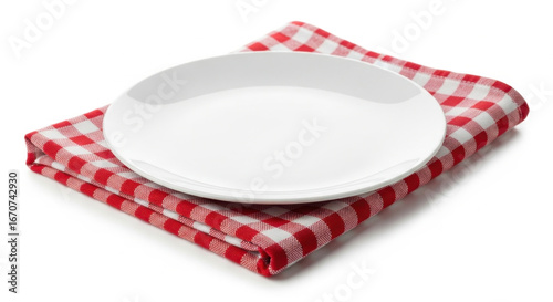 Empty white plate resting on red and white checkered napkin isolated on white background