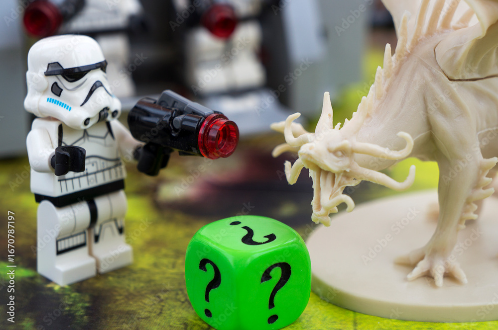 Naklejka premium Playing crossover game. Lego Star Wars storm troppers and a figure of dragon from Descent board game. Dice with question mark.