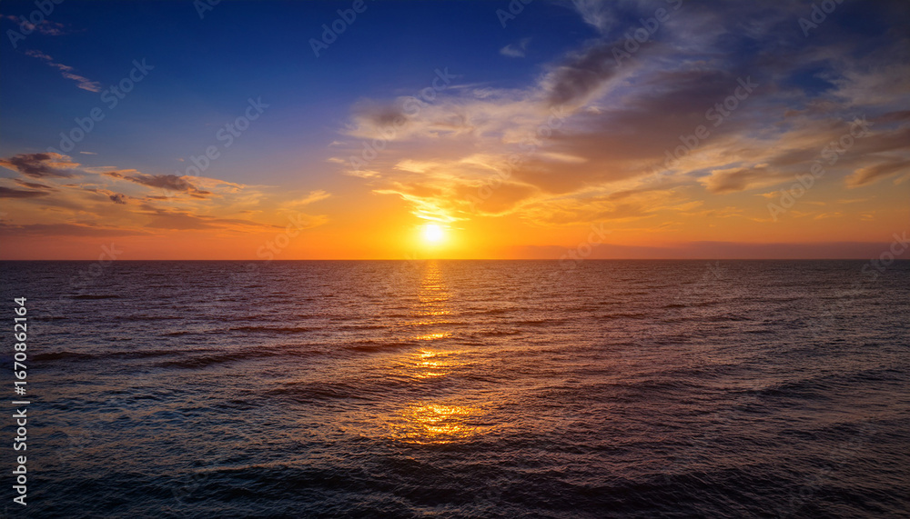 Fototapeta premium spectacular sunset over the ocean a breathtaking view of the sun dipping below the horizon casting a warm golden glow on the tranquil sea the serene scene is a perfect blend of
