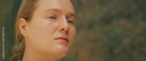 Close-up of woman gazes upward with contemplative thoughtful expression outdoors