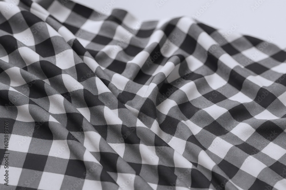Fototapeta premium Close-up of Black and White Gingham Fabric with Soft Draping, Ideal for Textile and Fashion Backgrounds