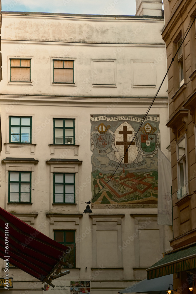Obraz premium Elegant historic building in Vienna with red roof, ornate facade and fresco. Classic European architecture and cultural heritage landmark in Austria.