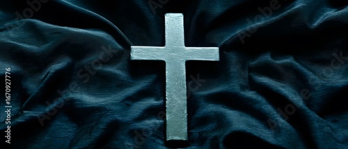 Silver Cross on Dark Teal Fabric Drape Background