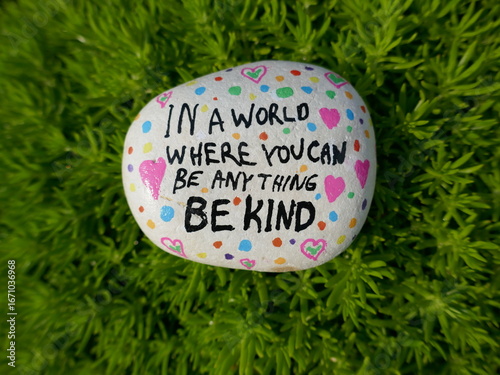 In a world where you can be anything be kind kindness rock on green moss
