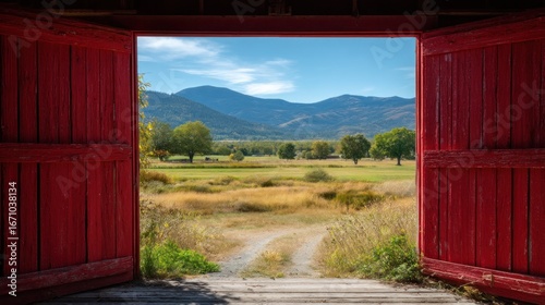 Barn door view of a scenic landscape with field trees and mountains