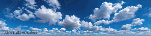 A vast expanse of a vivid blue sky dotted with fluffy white cumulus clouds
