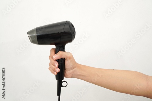 woman's hand holding a black hair dryer isolated on a white background