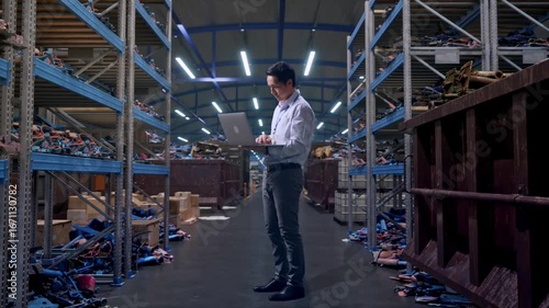 Wallpaper Mural Full Body Side View Of An Asian Male Professional Worker Standing With His Laptop, Industrial Scrap Metal and Recycling Warehouse, Typing On His Laptop'S Keybaord With Meditation Torontodigital.ca