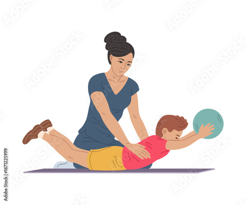 Physiotherapist helping boy with gym ball exercise lying on stomach