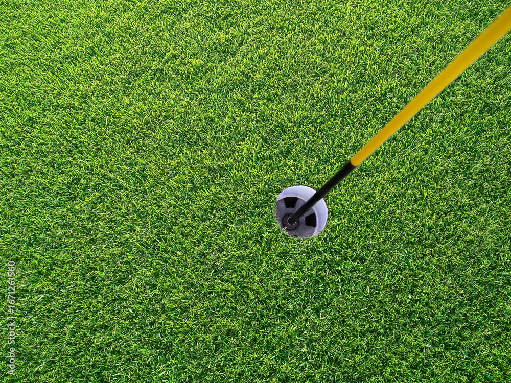Obraz premium Golf course hole with flag pole, close-up, view from above