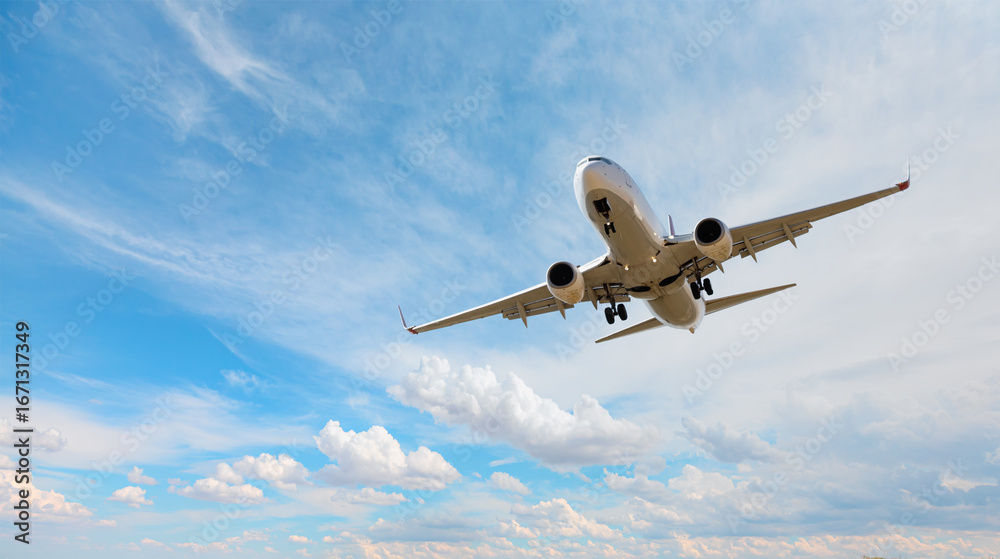 Obraz premium White passenger airplane flying in the sky amazing clouds in the background - Travel by air transport