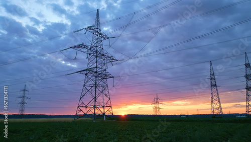Power lines and pylons silhouetted against a vibrant sunset, blending industrial strength with natural beauty, highlighting sustainable energy infrastructure.