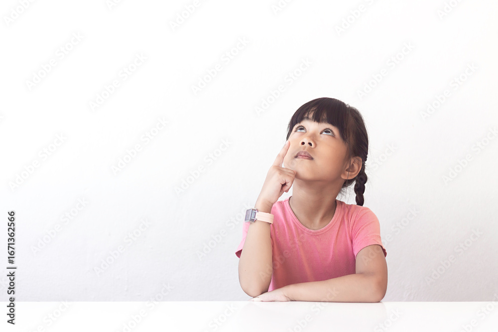 A girl looks up and points her finger, expressing some idea or thought, on a white background. A girl looks up and points her finger, expressing some idea or thought, on a white background.
