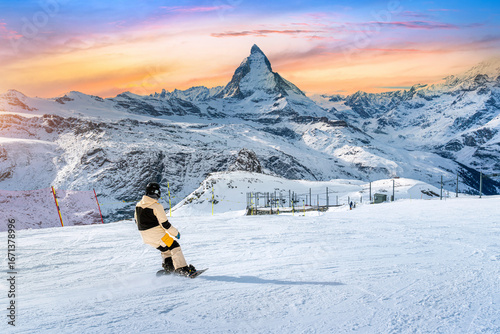 Skier skiing on the ski slope towards Matterhorn mountain in ski resort. Zermatt, Switzerland.