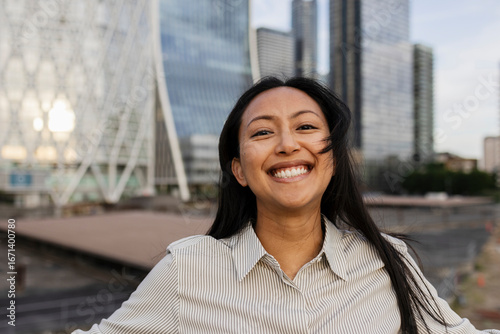 Professional smiling woman outdoors in business district cityscape