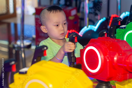 little boy playing games in arcade,