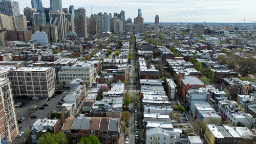 Aerial view of streets lined with dense buildings leading to distant skyscrapers under a muted sky, Philadelphia, Pennsylvania, United States.