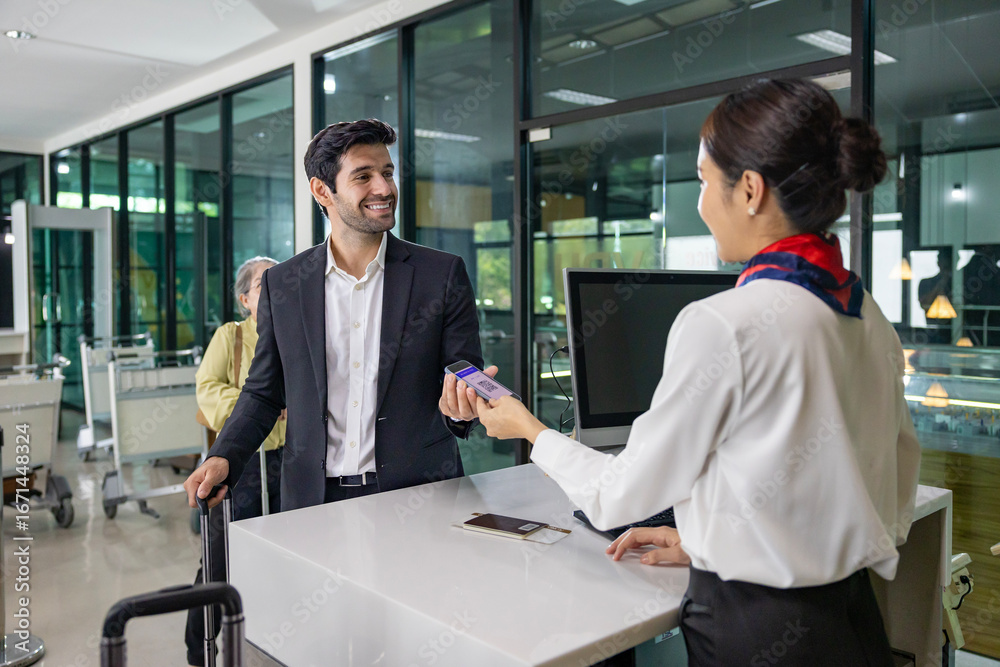 Fototapeta premium Caucasian businessman passenger is receiving boarding pass from the airline ground crew at check in counter at departure terminal into the airplane for final inspection before boarding to plane