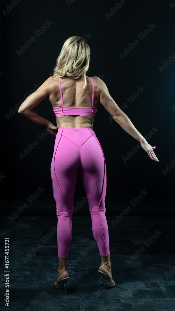 Obraz premium Athletic woman posing in pink sportswear on white background