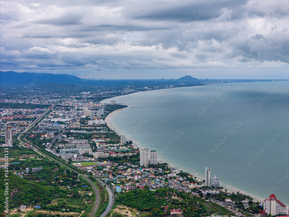 Fototapeta premium Aerial drone shot of Hua Hin city and Khao Takiab Nuea Beach under cloudy rainy season sky, favored by expats over 50