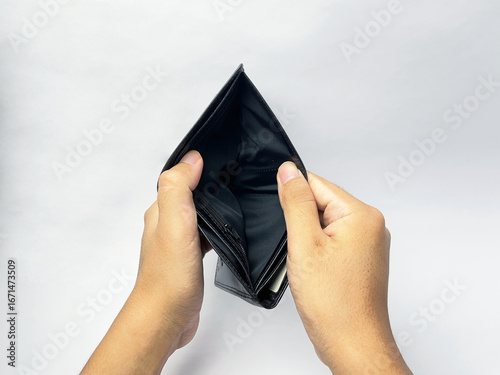 Empty black leather wallet held in hands, showcasing financial hardship