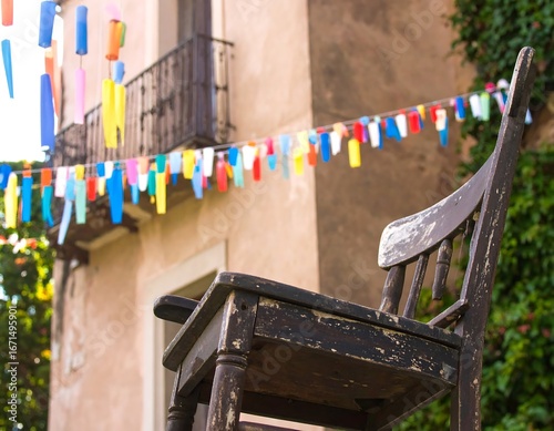 Old chair outdoors, festive backdrop, village