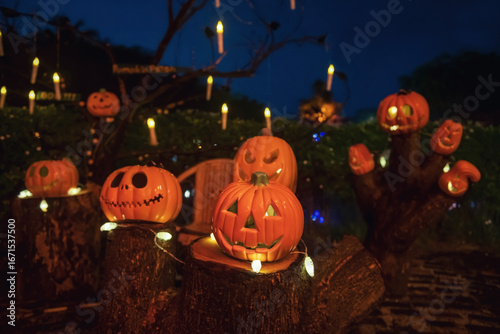 Many Pumpkin lanterns and hanging candles decor in park