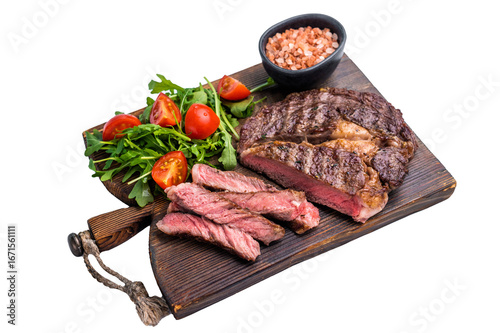 Bild auf Leinwand Rib eye steak with herbs on wooden board with salad, grilled prime beef meat iso