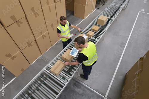Worker in a warehouse in the logistics sector processing packages on the assembly line  - transport and processing of orders in trade