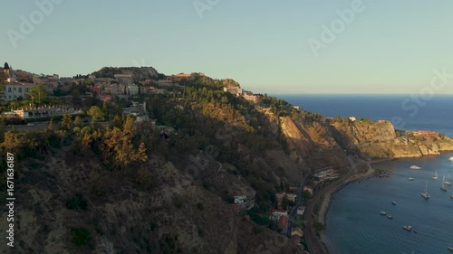 Aerial Drone Shot Flying Over The Scenic Taormina Coastline And Town, Sicily, Italy At Sunset