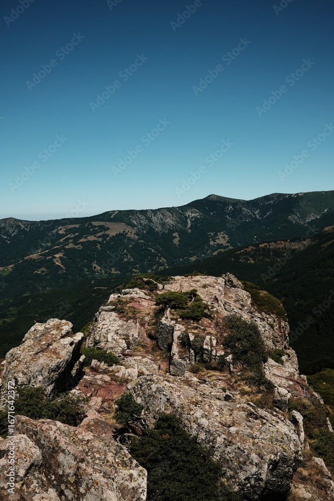 Naklejka premium Rocky cliffs and green slopes of Stara Planina with mountain ridges in the distance. Babin Zub mount in summer season. Serbia country