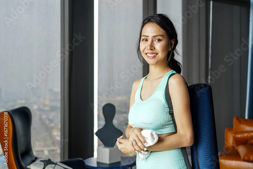Smiling Asian girl in sportswear with yoga mat using towel to wipe sweat after yoga practice exercise inside residence. Young sporty woman taking a break after home gym indoor, Workout sport concept Free Download Smiling Asian girl in sportswear with yoga mat using towel to wipe sweat after yoga practice exercise inside residence. Young sporty woman taking a break after home gym indoor, Workout sport concept - GFXLoad