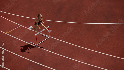 Photos Female track athlete sprinting and clearing hurdle in powerful action motion