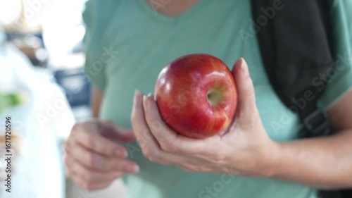 Woman holding an apple at a Local harvest market
