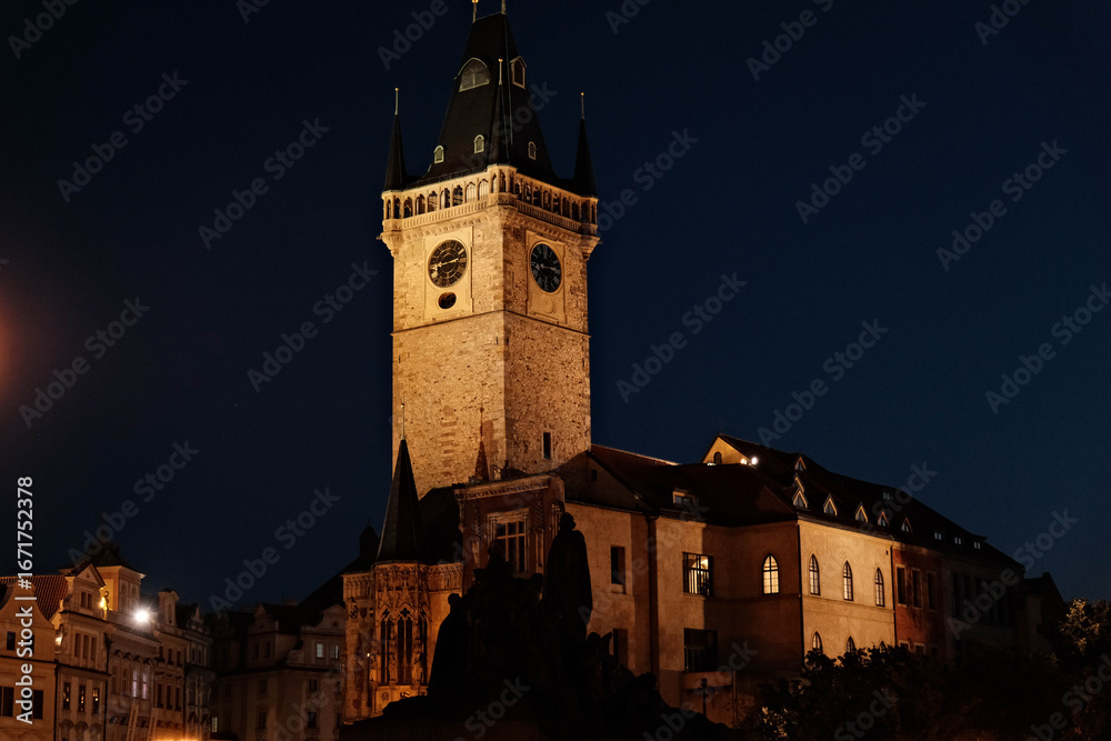 Fototapeta premium Prague's clock tower illuminated at night in the famous Czech square with various monuments on an August evening in 2025