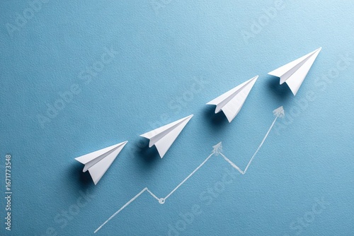 Paper airplanes ascending a line on a blue background