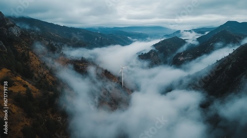 Misty mountain valley with wind turbine