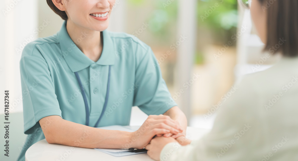 Obraz premium カウンセラーが両手で相談者の手を包み込んている。