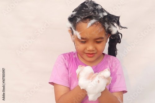 Asian girls have fun playing with soap foam.