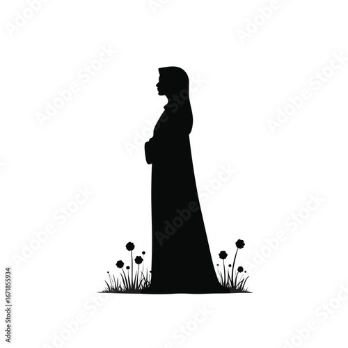 Black silhouette of a woman in a hijab standing in grass with flowers