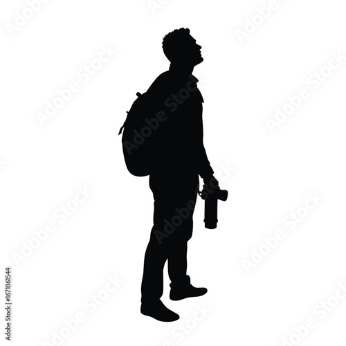 Silhouette of a man with backpack holding camera looking up