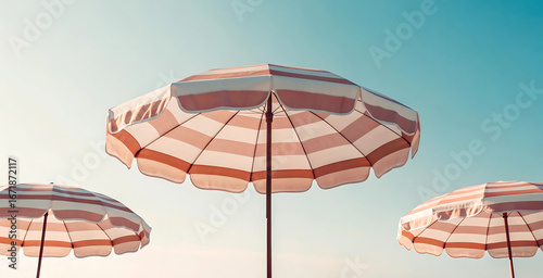 A tranquil summer scene featuring three retro-style pink and white striped beach umbrellas against a clear, minimalist turquoise sky