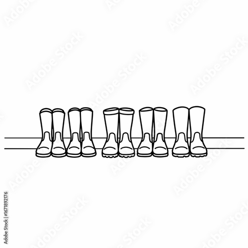 Line of rubber boots arranged neatly on a shelf against a white background  