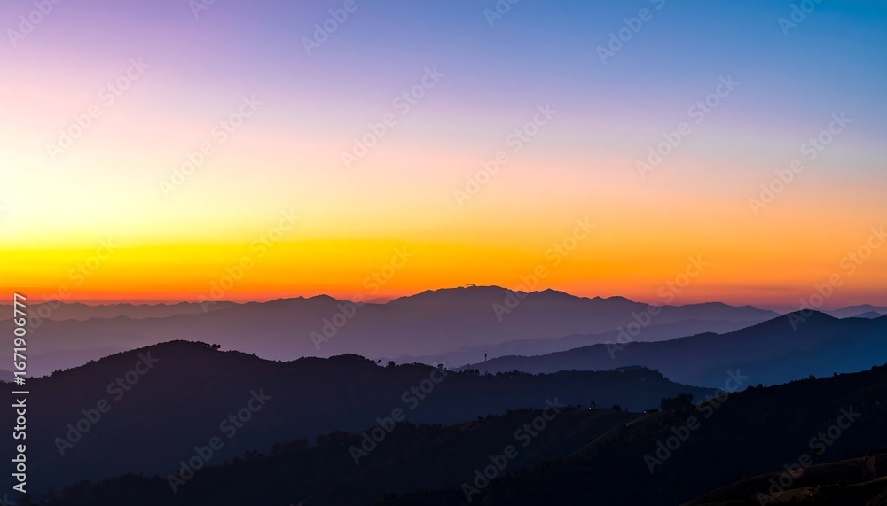 Obraz premium A breathtaking sunrise paints the mountain ranges in hues of orange, purple, and blue, creating a serene and majestic view.
