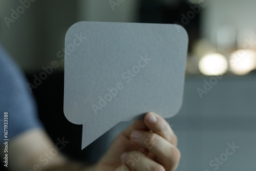 Hand holding a gray speech ...