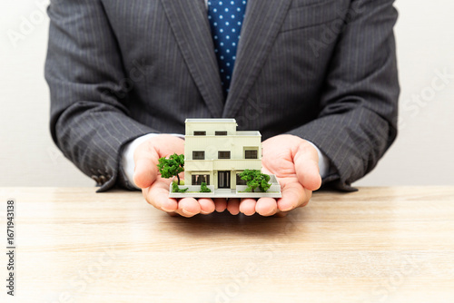 家の模型とビジネスマン