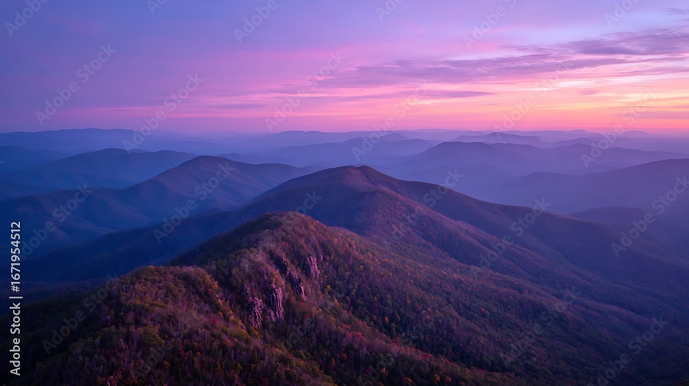Fototapeta premium mountain ridge shrouded in mist at sunrise beneath purple sky 