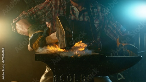 Foto The blacksmith manually forging the molten metal on the anvil in smithy with spa