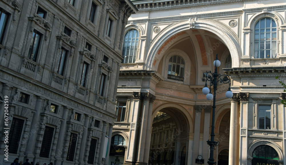 Fototapeta premium The Galleria Vittorio Emanuele II is Milan's famous shopping arcade connecting Piazza Duomo to Piazza della Scala. It is renowned for its glass dome, porticoes, and prestigious shops.